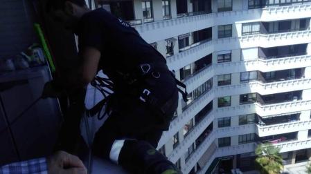 Un bombero, en la ventana de la mujer en la calle Abejeras.