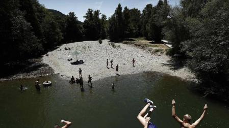 Varias personas se alivian del calor en el pantano de Alloz y en el río Arga a su paso por Irotz.