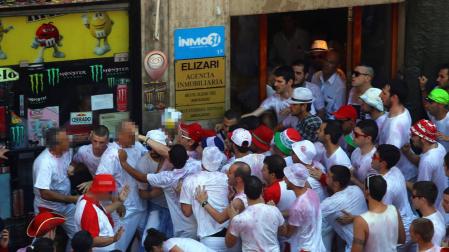 Jóvenes y policías municipales de paisano durante el forcejo en el portal.