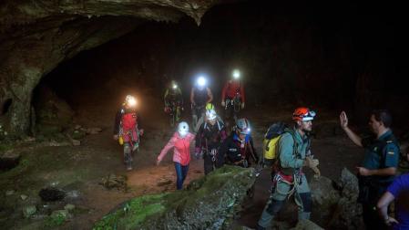 Las tres espeleólogas salen de la cueva acompañadas del equipo de rescate.