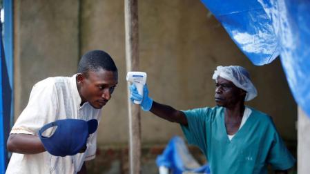 Foto de dos trabajadores sanitarios toman las medidas necesarias ante la epidemia de ébola detectada en el país.