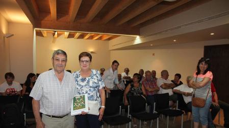 Félix Milagro, con su libro y junto a su mujer, Amparo Chueca, ante parte de los asistentes al acto