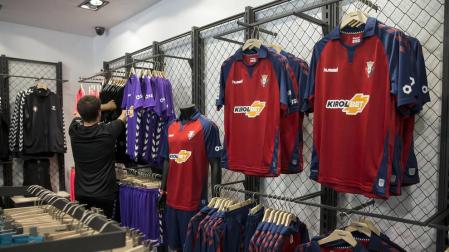 Un cliente supervisa las camisetas de portero. A la derecha, la primera equipación expuesta en la tienda del club de El Sadar.