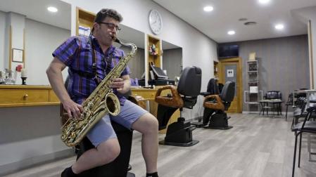 José Javier Zazpe toca el saxofón en su peluquería de la calle Alberto Magno.