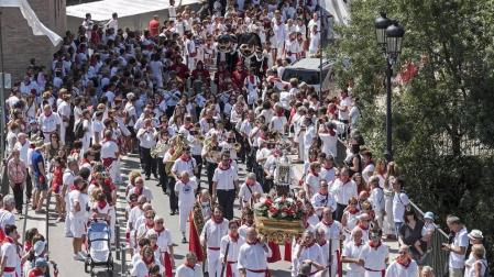 La reliquia de San Andrés enfila el puente del Azucarero en la retaguardia de la larga procesión. Detrás, los párrocos, la banda y la corporación municipal.