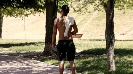 Un joven pasea sin camiseta a causa del calor.