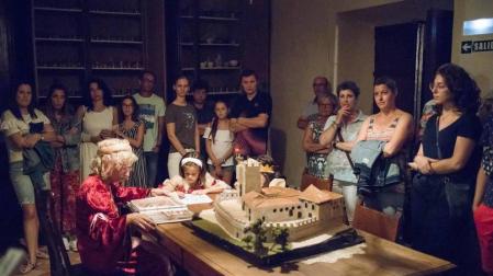 Los visitantes miran con atención a las infantas, que dibujan bajo la supervisión de una dama en el comedor habilitado para ellas