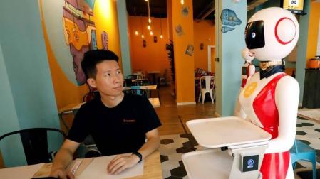 Se llama Crensa y es un restaurante que abre este lunes en el barrio valenciano de Benimaclet, pero con algo que le hace único en España: sus dos camareras son robots, responden al nombre de Mulán y sirven los pedidos con tanta educación como al pedir paso para llevar sus platos y llamar cariño al cliente.En la imagen, el dueño chino del restaurante, Erik Yan