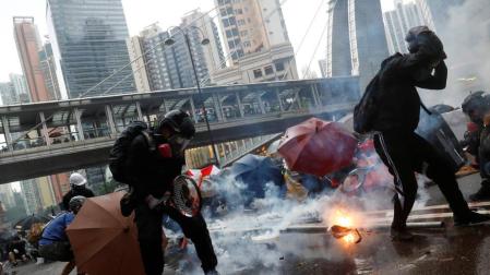 Manifestantes se defienden del gas lacrimógeno de la policía en Hong Kong.