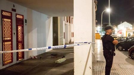 Miembros de la Policía Nacional vigilan la zona donde un hombre ha sido encontrado muerto con herida de arma de fuego este lunes en Fuengirola (Málaga).