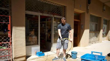 Un comerciante limpia las inmediaciones de su establecimiento tras las lluvias torrenciales del 8 de julio pasado