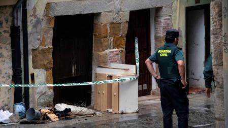 Agentes de la Guardia Civil junto a la vivienda de Laredo en la que han fallecido una mujer y su hija de 7 años a causa de un incendio.