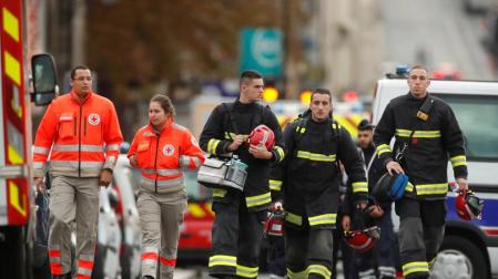 Policías y bomberos frente al cuartel de la Policia de París tras el ataque del jueves.