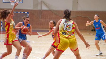 Irantzu Etxeberria trata de avanzar a canasta ante la oposición de tres jugadoras del UniGirona.