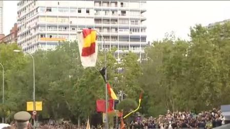 Un paracaidista se queda enganchado a una farola en el desfile del Día de la Hispanidad