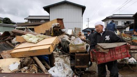 Un hombre transporta enseres afectados por las inundaciones en Nagano.