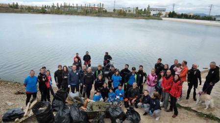 Los participantes posaron al final de la actividad con la basura recogida en el fondo y la orilla de la balsa.