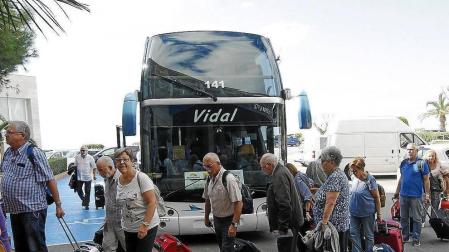 Un grupo de jubilados llega en autobús hasta la entrada de un establecimiento hotelero.