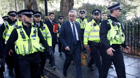 Michael Gove es escoltado en su camino al Parlamento inglés.