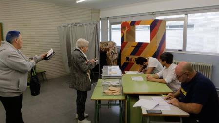 Varias personas votando en un colegio electoral del barrio de Mendillorri en Pamplona