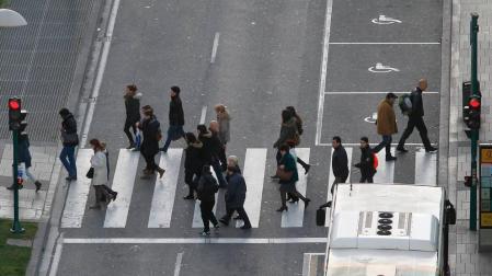 Varias personas cruzan un paso de peatones de Pamplona.
