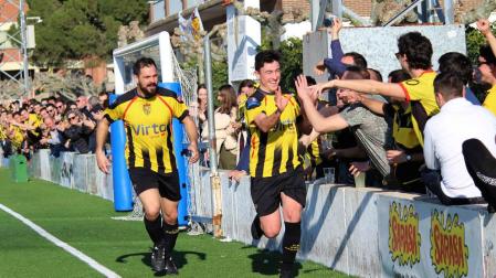 Arriba, aficionados de la Peña tras el muro celebran un gol de su equipo.