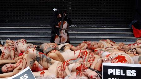 Activistas protestan contra la industria peletera simulando ser animales desollados