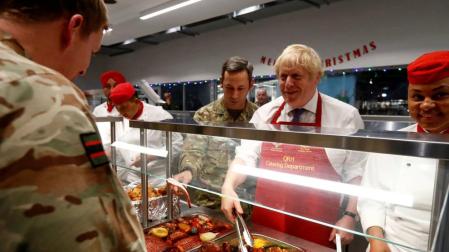 Boris Johnson visita a sus tropas en Estonia y les sirve comida prenavideña