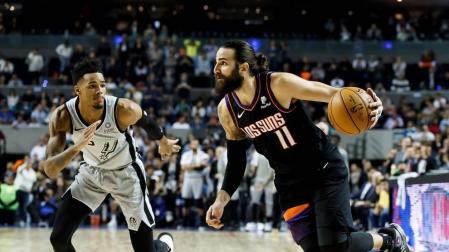 El jugador de los Phoenix Suns, Ricky Rubio, conduce el balón ante Dejounte Murray de los San Antonio Spurs