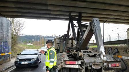 Imagen de la Guardia Civil regulando el tráfico tras el choque de la grúa -a la derecha- con el puente.