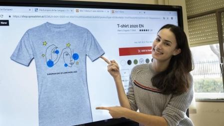 Catalina Puebla muestra la camiseta oficial del Día Europeo de las Lenguas de 2020 con su dibujo.