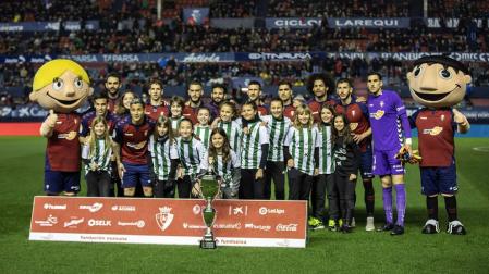 El once de Osasuna se fotografía con las jugadoras de Paz de Ziganda, campeonas del Interescolar.