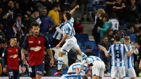 Rubén García y Roncaglia, cabizbajos, mientras los jugadores de la Real celebran uno de sus goles.