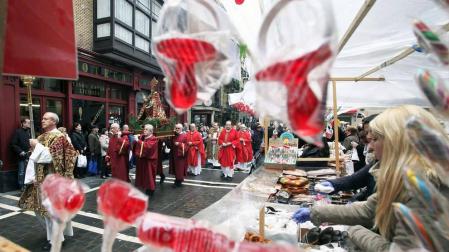La procesión de San Blas pasa ante el tradicional mercadillo de roscos y dulces.