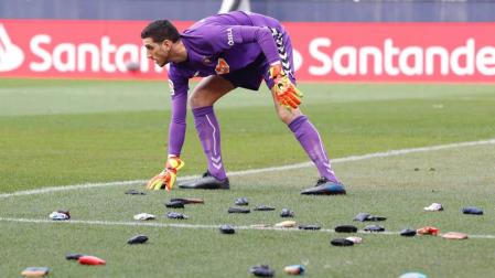 Sergio Herrera recoge una de las carteras lanzadas desde la grada de El Sadar.