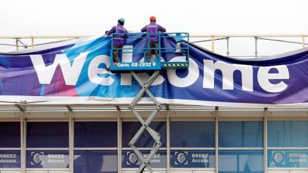 Dos trabajadores en la Fira de Barcelona donde se ultiman los preparativos para el Congreso Mundial de Móviles (MWC) de Barcelona, este miércoles.