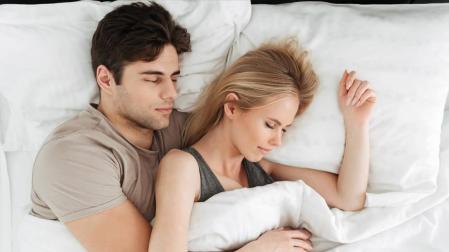 Una pareja durmiendo en la cama.
