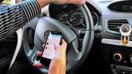 Un conductor usando el móvil al volante