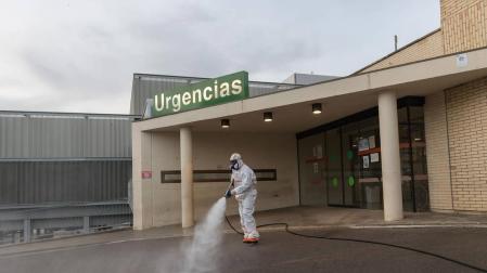 Un voluntario de Protección Civil fumiga los accesos al Hospital Reina Sofía.