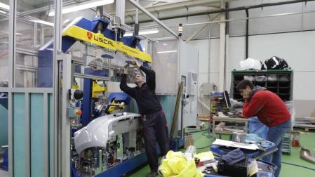 Operarios de Uscal trabajan con una máquina.