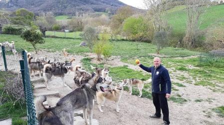 Baltasar Gallardo, junto a algunos de los perros con los que convive y compite en carreras de trineos, en el terreno de su casa