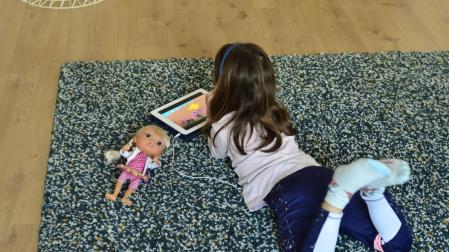 Una niña lee en el salón de su casa.
