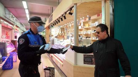 Agentes reparten mascarillas para prevenir el coronavirus en Pamplona.