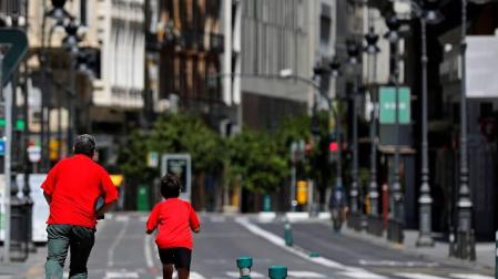 Un niño y un adulto, en una calle de Valencia.