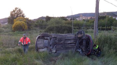 Un agente de la Policía Foral, junto al vehículo accidentado.