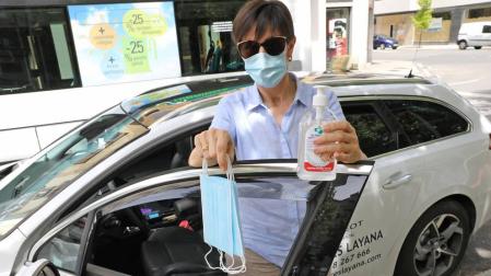 Mari José Mendiburu, en su taxi, con las mascarillas que tiene para los pasajeros.