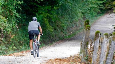 Un ciclista, por el sendero que rodea el pantano de Eugui.