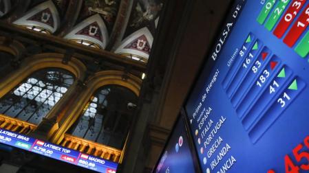 Vista de los paneles que informan sobre la prima de riesgo en el parqué de la Bolsa de Madrid este jueves.