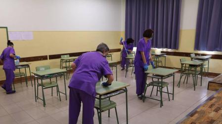El equipo de limpieza del Instituto Plaza de la Cruz de Pamplona se afana en la desinfección de los espacios que van a abrirse a los alumnos. En las aulas se han distanciado las mesas reduciendo el aforo a 15 estudiantes y cada pupitre se higienizará después de cada uso.