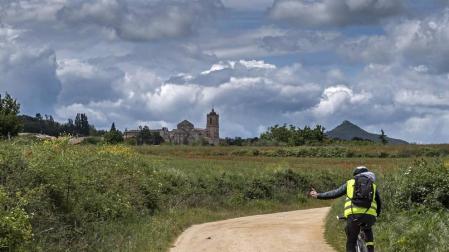Un ciclista circula por una pista del entorno de Ayegui que lleva hasta el Monasterio de Irache, al fondo de la imagen.